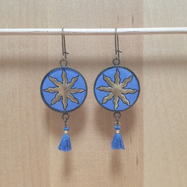 Boucles d'oreille pendantes soleil dor&eacute; sur fond bleu