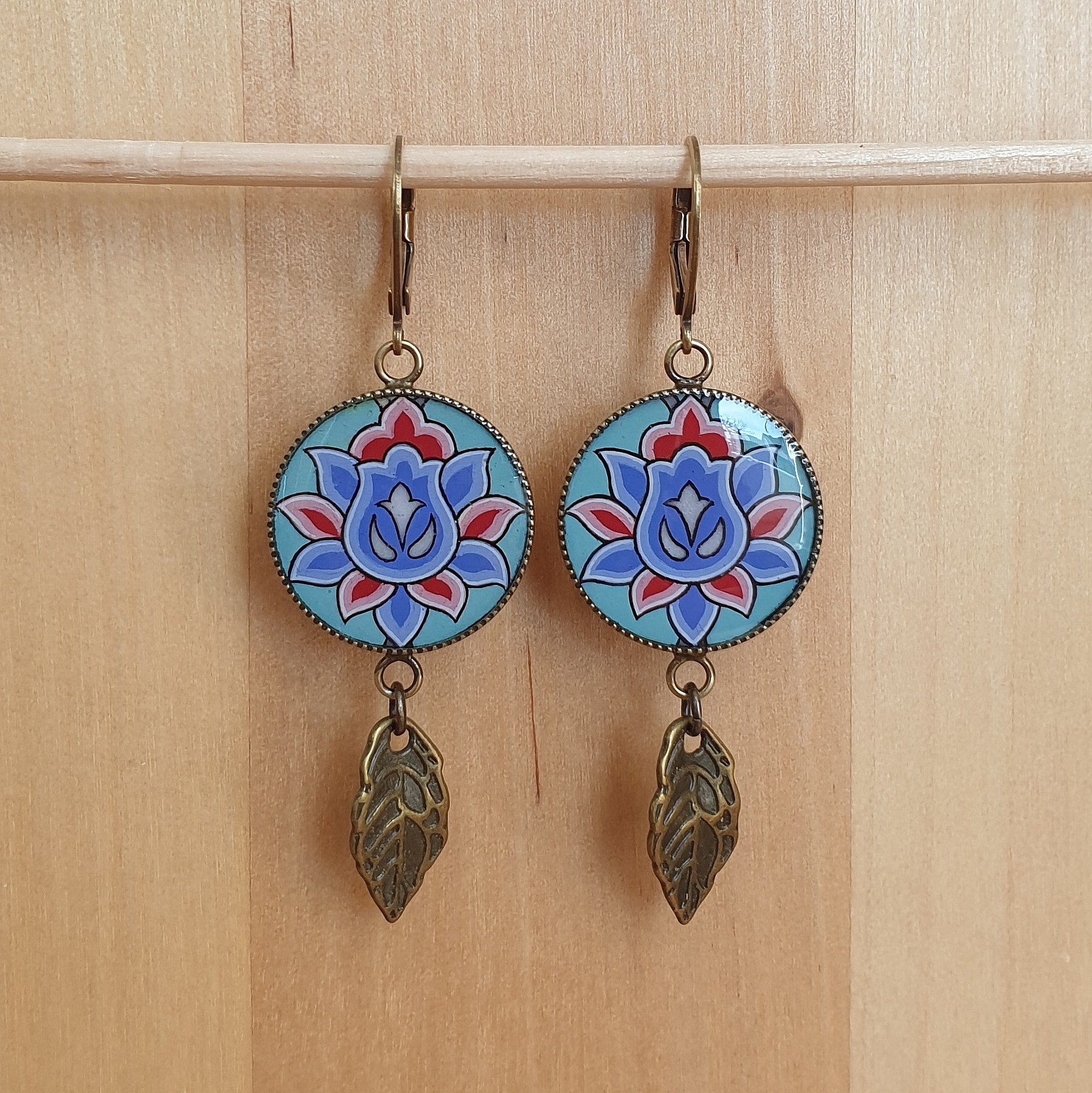 Boucles d'oreille pendantes enlumin&eacute;es fleur orientale sur fond vert