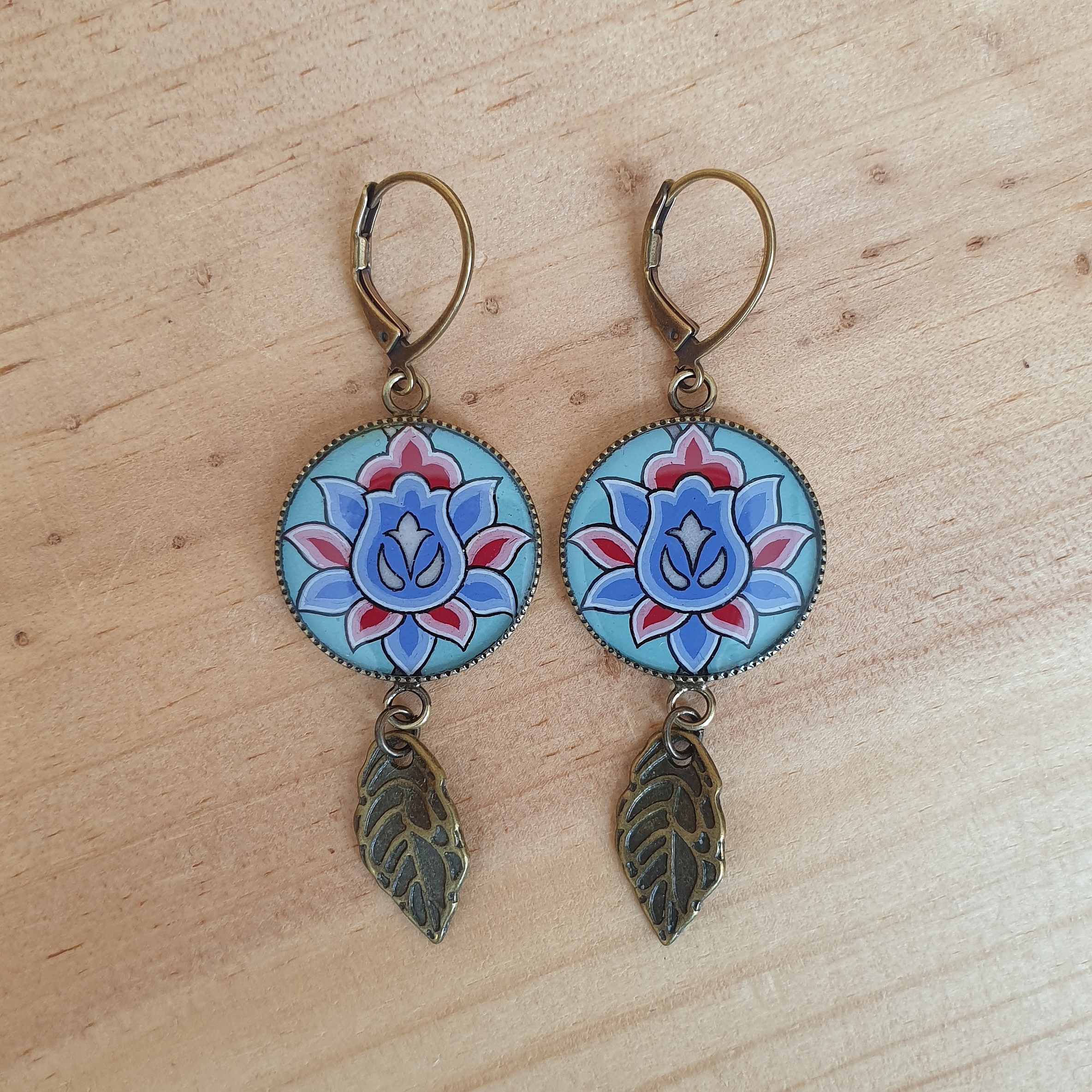 Boucles d'oreille pendantes enlumin&eacute;es fleur orientale sur fond vert