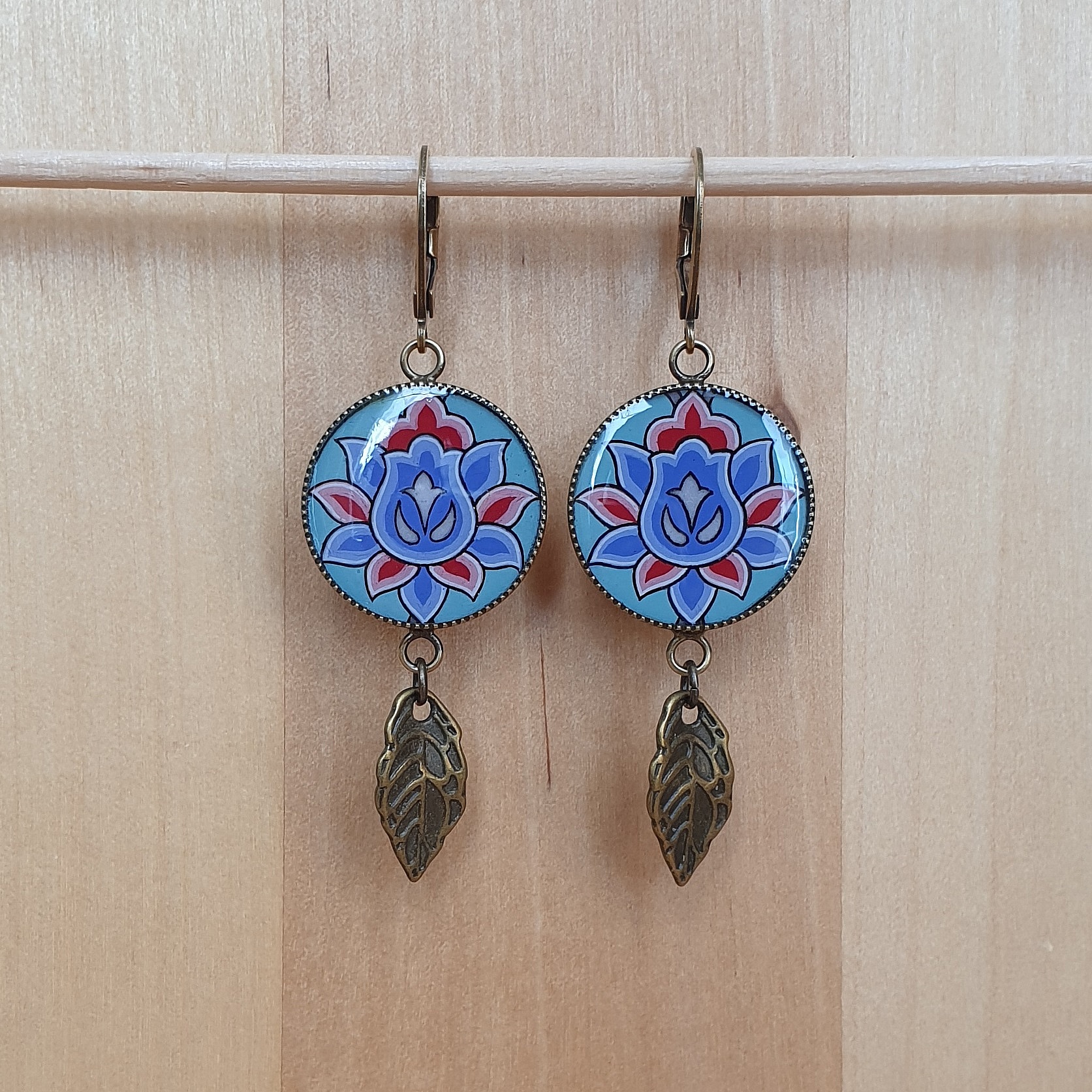 Boucles d'oreille pendantes enlumin&eacute;es fleur orientale sur fond vert