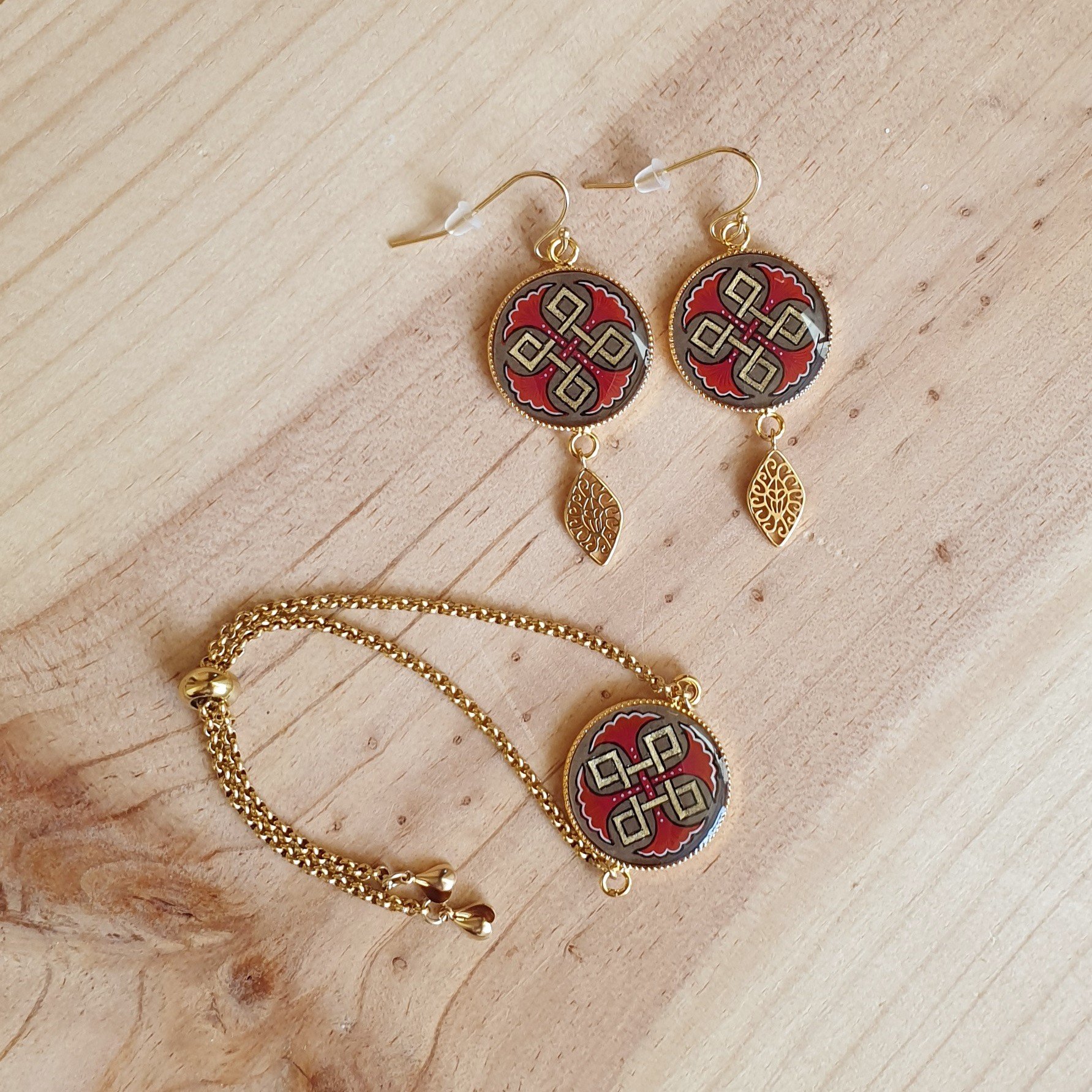 Bracelet r&eacute;glable entrelacs or et palmettes rouges ou bleues