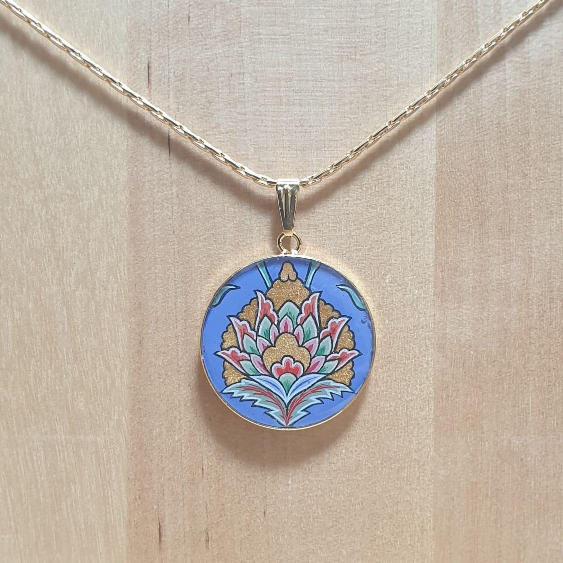 Collier pendentif fleur orientale fond bleu