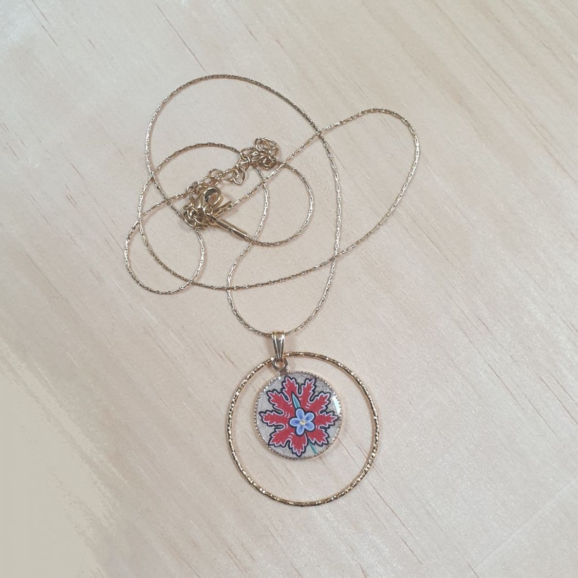 Collier pendentif fleur orientale rouge sur chaîne dorée